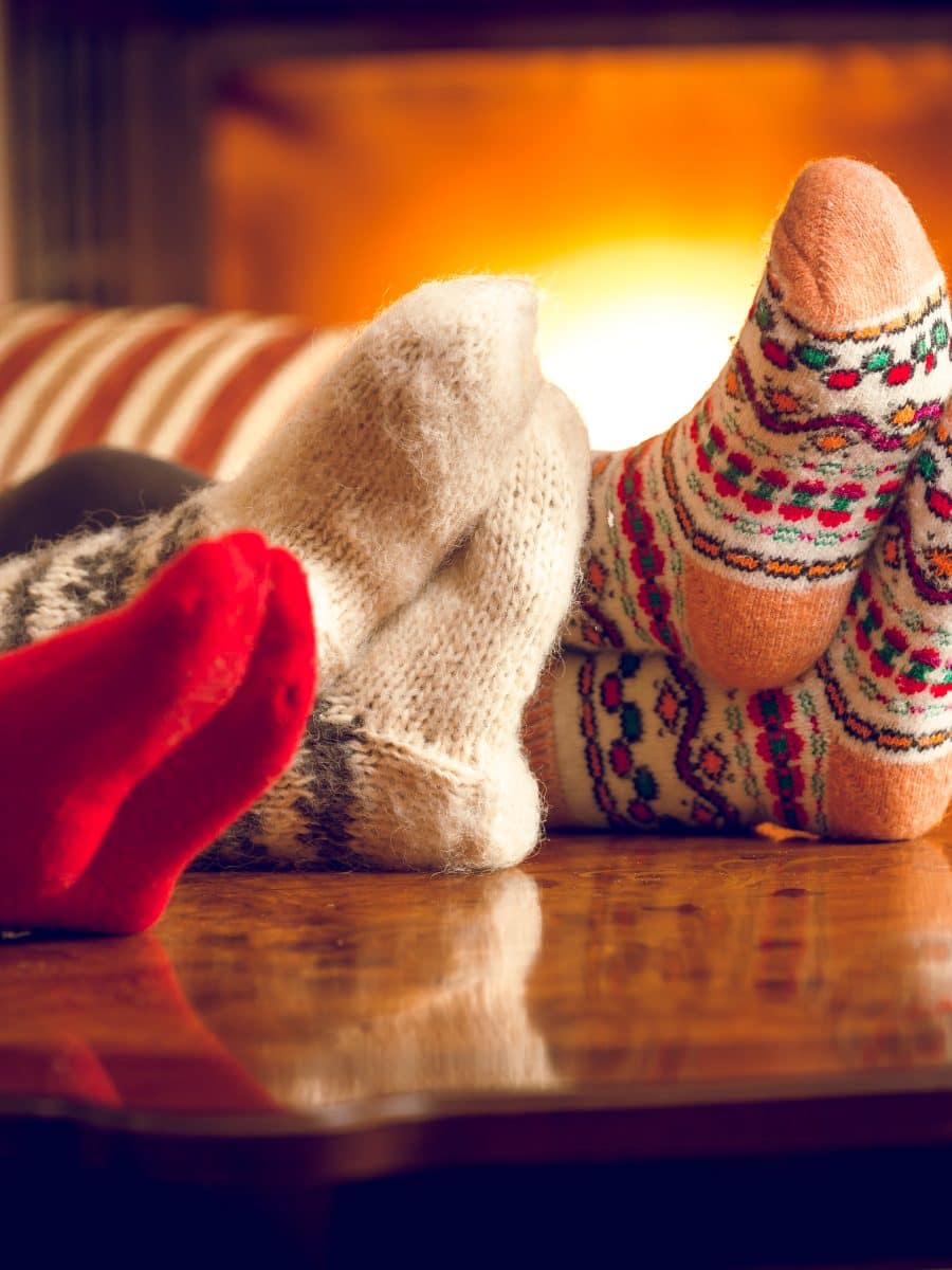 Closeup of family warming feet at fireplace Closeup of family warming feet at fireplace
