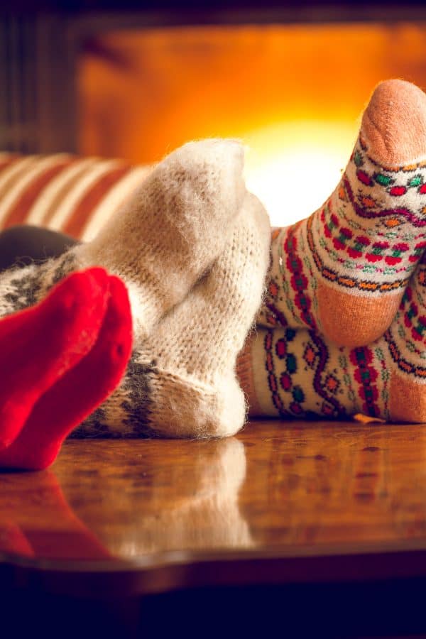 Closeup of family warming feet at fireplace