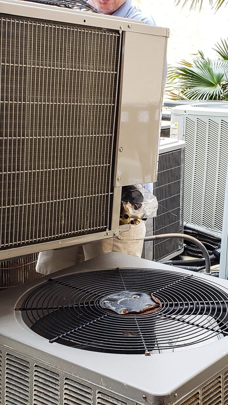 People from behind lifting heating and cooling unit to replace with new one. People from behind lifting heating and cooling unit to replace with new one.